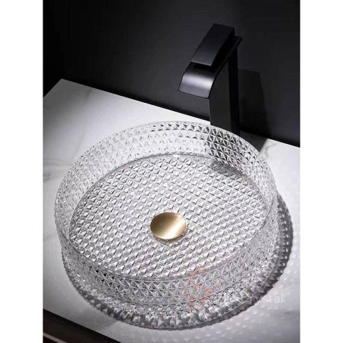 This Prism Round Crystal Washbasin-Clear features a sculptural round vessel silhouette defined by dense prism-like faceted crystal detailing across the entire basin surface. Its transparent crystal construction amplifies the geometric pattern through strong light refraction, creating a jewel-like visual effect that enhances refined vanity and decorative bathroom interiors. The wide round vessel form provides generous washing space while maintaining a clean low-profile countertop presence, making it suitable for luxury residential bathrooms, boutique hospitality interiors, and contemporary vanity installations. The symmetrical circular geometry allows the faceted surface pattern to remain visually balanced from every viewing angle. The basin is manufactured through precision molding to create a consistent geometric prism glass basin structure, allowing the dense faceted texture to be integrated uniformly across the inner wall, outer wall, and base surface. This production method ensures accurate pattern definition, balanced wall thickness, and structural consistency across repeated OEM manufacturing. Designed for decorative vanity environments, upscale hospitality interiors, and premium architectural bathroom projects, this geometric prism glass basin combines functional performance with crisp geometric elegance. SHD Crystal provides custom crystal washbasin OEM services including texture redevelopment, dimensional modification, color customization, drain adaptation, and bespoke production support for private label and project-based clients.